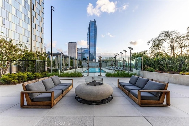 view of patio / terrace featuring an outdoor living space with a fire pit and fence
