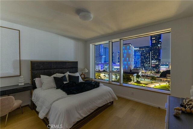 bedroom with baseboards and wood finished floors