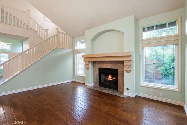 29827 Via Sevilla, Temecula, CA 92591 - unfurnished living room featuring stairway, hardwood / wood-style flooring, a tile fireplace, baseboards, and a high ceiling
