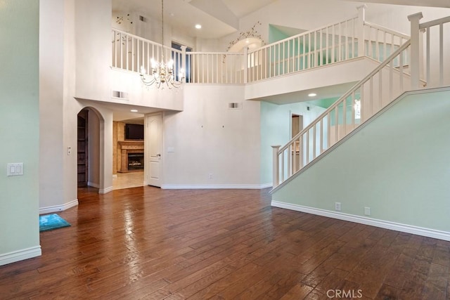 29827 Via Sevilla, Temecula, CA 92591 - unfurnished living room with wood-type flooring, a towering ceiling, and baseboards