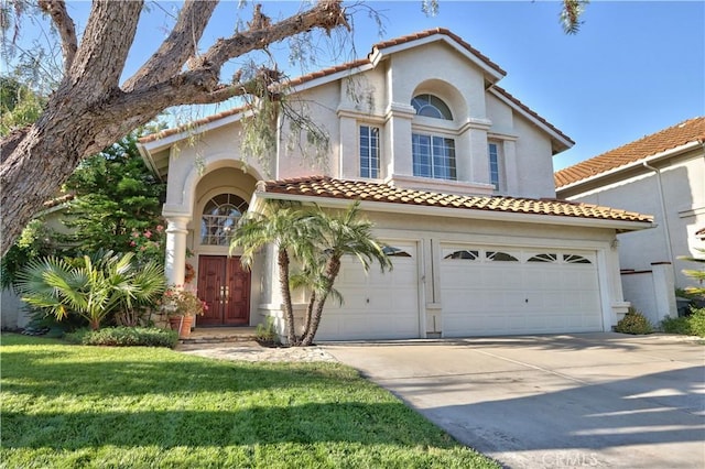 mediterranean / spanish-style home featuring driveway, a tiled roof, a garage, stucco siding, and a front yard
