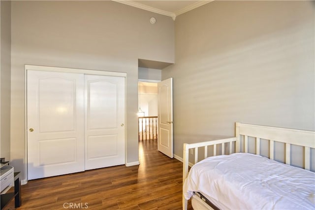 bedroom featuring ornamental molding, wood finished floors, a closet, and baseboards