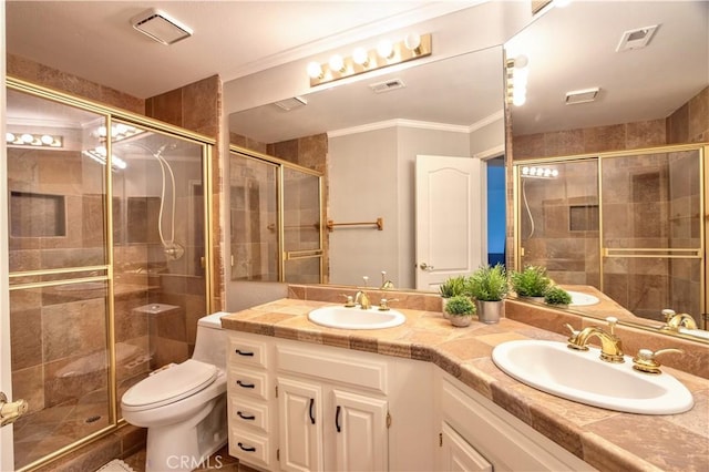 full bathroom with a stall shower, ornamental molding, double vanity, and toilet