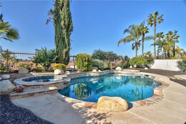 view of pool with a fenced backyard and a pool with connected hot tub