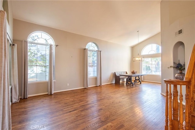 dining area with hardwood / wood-style flooring, lofted ceiling, baseboards, and a chandelier