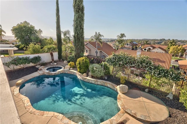 view of pool featuring a residential view, a fenced backyard, a pool with connected hot tub, and a patio