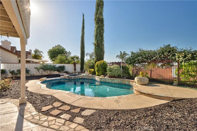 view of swimming pool featuring a fenced backyard, a patio area, and a pool with connected hot tub