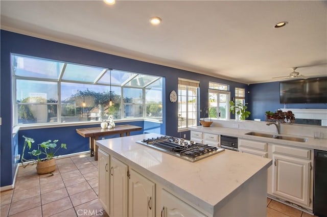 kitchen featuring stainless steel gas stovetop, a sink, light tile patterned floors, white cabinetry, and a ceiling fan