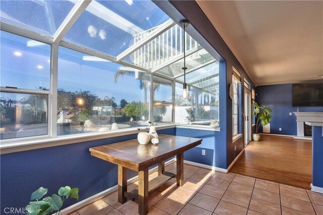 sunroom / solarium with tile patterned flooring and baseboards