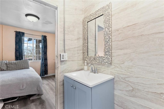 bathroom featuring tile walls, wood finished floors, and vanity