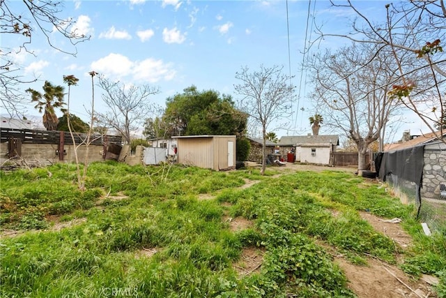 view of yard with a fenced backyard, an outdoor structure, and a shed