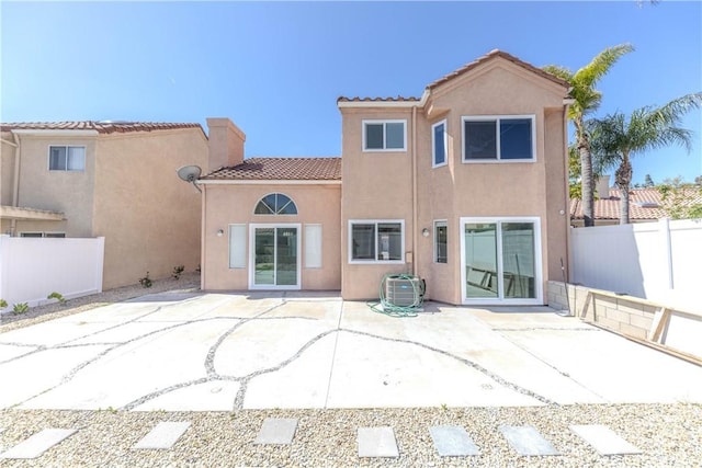 back of house featuring a patio, a fenced backyard, stucco siding, and a tile roof
