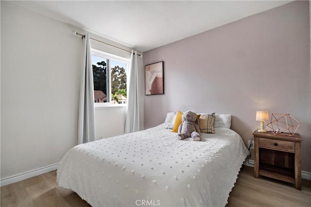 bedroom featuring baseboards and wood finished floors