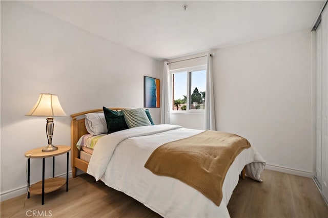 bedroom with baseboards and wood finished floors