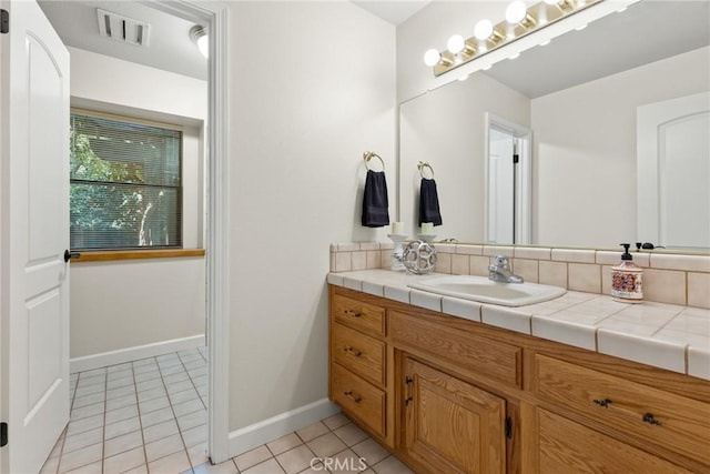 bathroom with visible vents, tile patterned floors, baseboards, and vanity