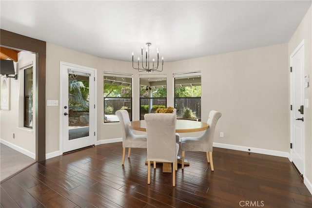 dining area with baseboards, a notable chandelier, and wood finished floors