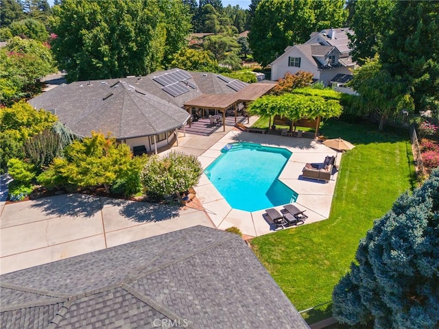 outdoor pool featuring a lawn, fence, and a patio