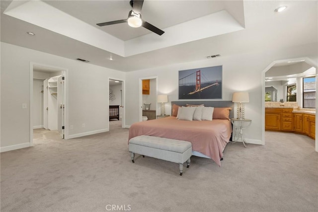 650 Crimson Ct, Chico, CA 95973 - bedroom featuring light carpet, a walk in closet, a raised ceiling, connected bathroom, and baseboards