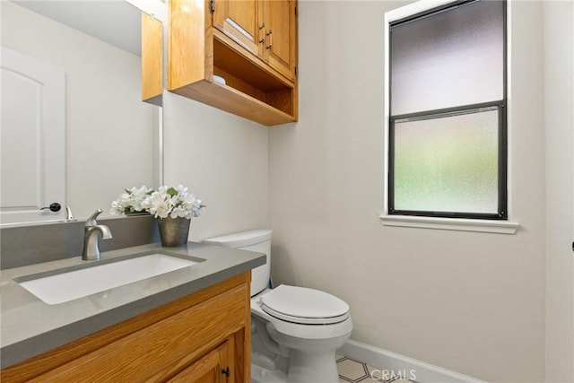 half bath featuring tile patterned flooring, baseboards, toilet, and vanity