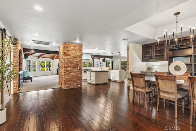 dining area with ornate columns, an inviting chandelier, dark wood-style flooring, visible vents, and recessed lighting