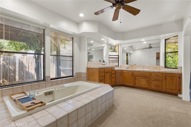 full bath with a garden tub, a ceiling fan, vanity, and a healthy amount of sunlight