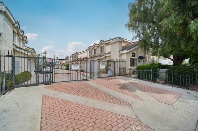 view of front of property with a gate, a residential view, stucco siding, and fence