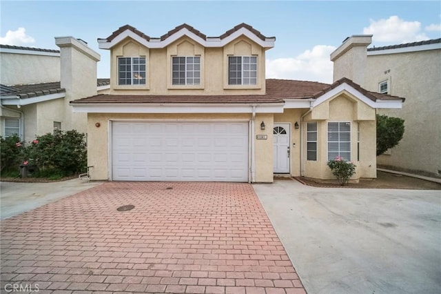 21021 Gault St Unit 9, Canoga Park, CA 91303 - view of front of home with decorative driveway, stucco siding, a garage, and a tile roof