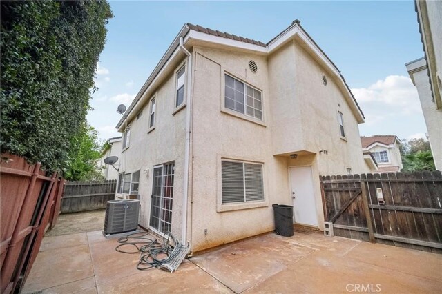 21021 Gault St Unit 9, Canoga Park, CA 91303 - back of property with stucco siding, a patio area, a fenced backyard, central AC unit, and a tiled roof