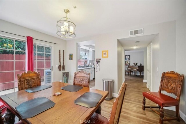 21021 Gault St Unit 9, Canoga Park, CA 91303 - dining area featuring a chandelier, light wood finished floors, and baseboards