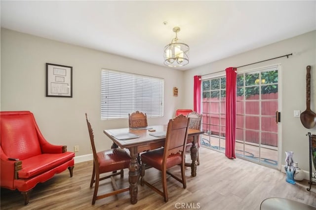 dining area featuring an inviting chandelier, wood finished floors, and baseboards