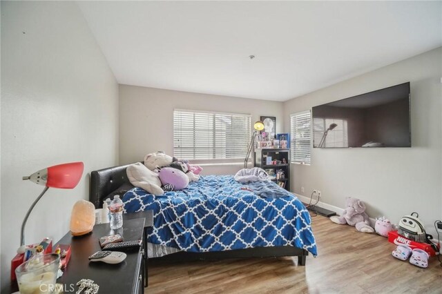 bedroom featuring baseboards and wood finished floors
