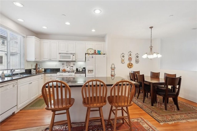 763 W 1st St Unit 80, Claremont, CA 91711 - kitchen featuring dark countertops, light wood-style floors, a sink, and white appliances