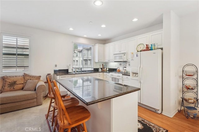 763 W 1st St Unit 80, Claremont, CA 91711 - kitchen featuring recessed lighting, dark countertops, a kitchen breakfast bar, and white appliances