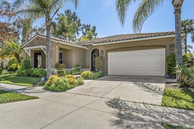 1450 Oakpoint Ave, Chula Vista, CA 91913 - view of front of home featuring stucco siding, an attached garage, driveway, and a tile roof