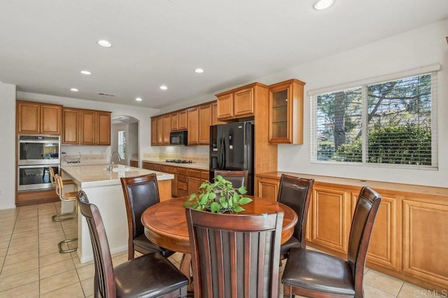 1450 Oakpoint Ave, Chula Vista, CA 91913 - kitchen with black appliances, brown cabinets, light countertops, recessed lighting, and a kitchen island with sink