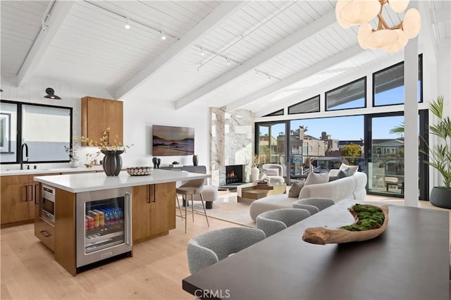 4017 Channel Pl, Newport Beach, CA 92663 - interior space with a fireplace, lofted ceiling with beams, track lighting, light wood-type flooring, and wine cooler