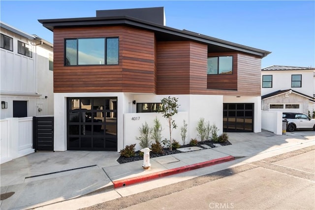 4017 Channel Pl, Newport Beach, CA 92663 - contemporary home with an attached garage, concrete driveway, stucco siding, and fence