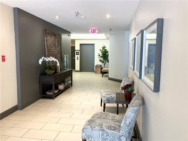 corridor featuring recessed lighting, baseboards, and light tile patterned floors