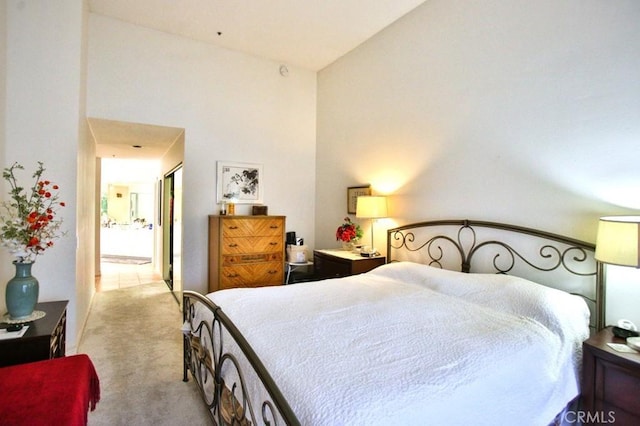 carpeted bedroom featuring a towering ceiling