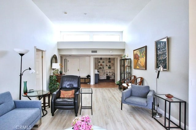 living room with wood finished floors and a high ceiling