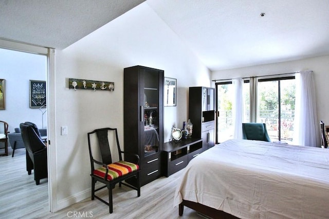 bedroom with baseboards, light wood-style flooring, and lofted ceiling