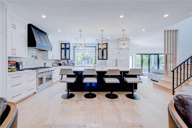 1852 6th St, Manhattan Beach, CA 90266 - kitchen with range with two ovens, custom exhaust hood, open floor plan, light countertops, and plenty of natural light