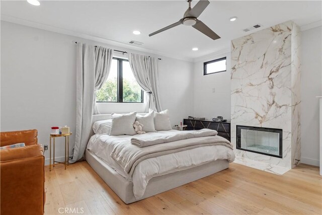 1852 6th St, Manhattan Beach, CA 90266 - bedroom with multiple windows, light wood-type flooring, recessed lighting, ornamental molding, and a high end fireplace