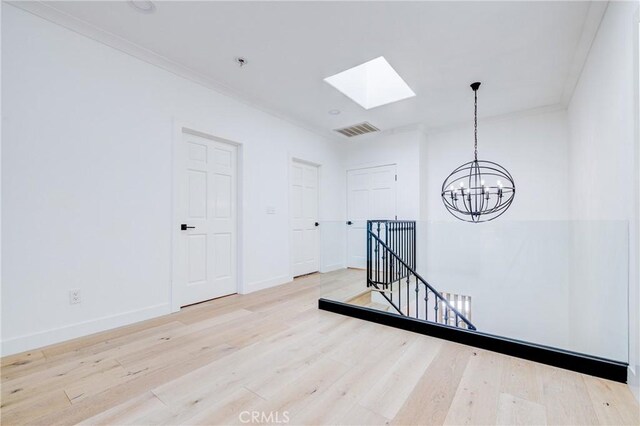 1852 6th St, Manhattan Beach, CA 90266 - spare room with a skylight, a chandelier, wood finished floors, ornamental molding, and baseboards