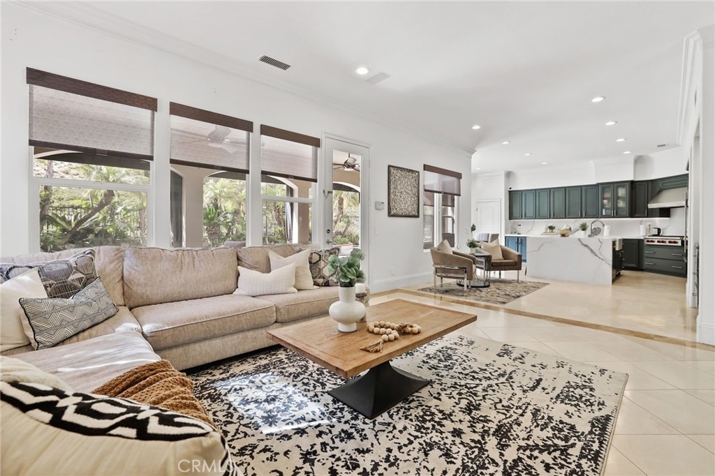 living room featuring recessed lighting, crown molding, and light tile patterned floors