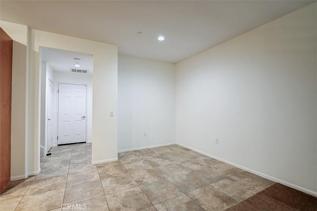 unfurnished room with baseboards, visible vents, and recessed lighting