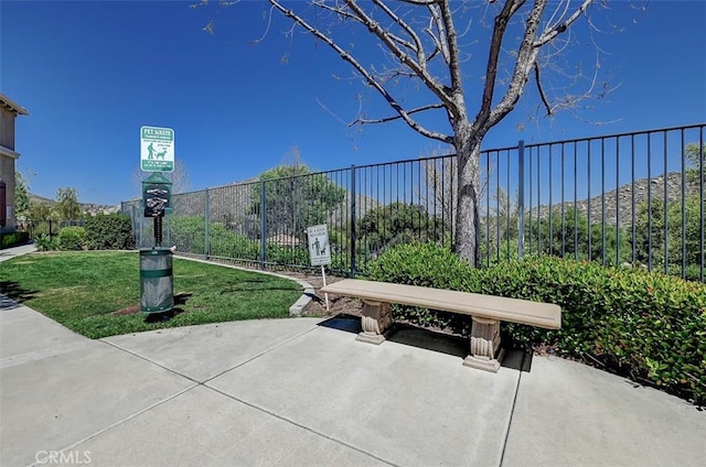 view of home's community with a yard, a patio area, and fence