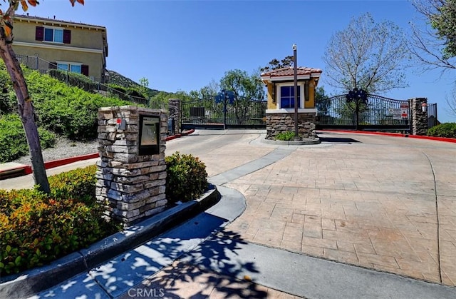 view of home's community with fence and a gate