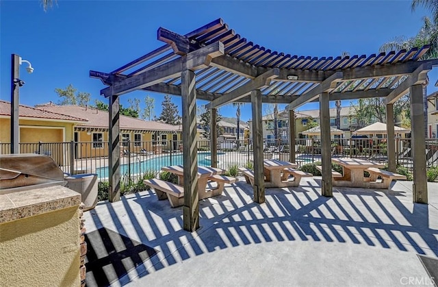 view of patio / terrace with fence, a pergola, a community pool, and exterior kitchen