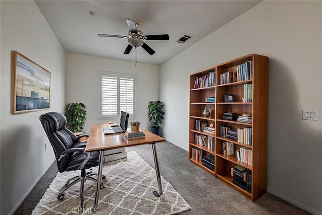 office with carpet, visible vents, and ceiling fan